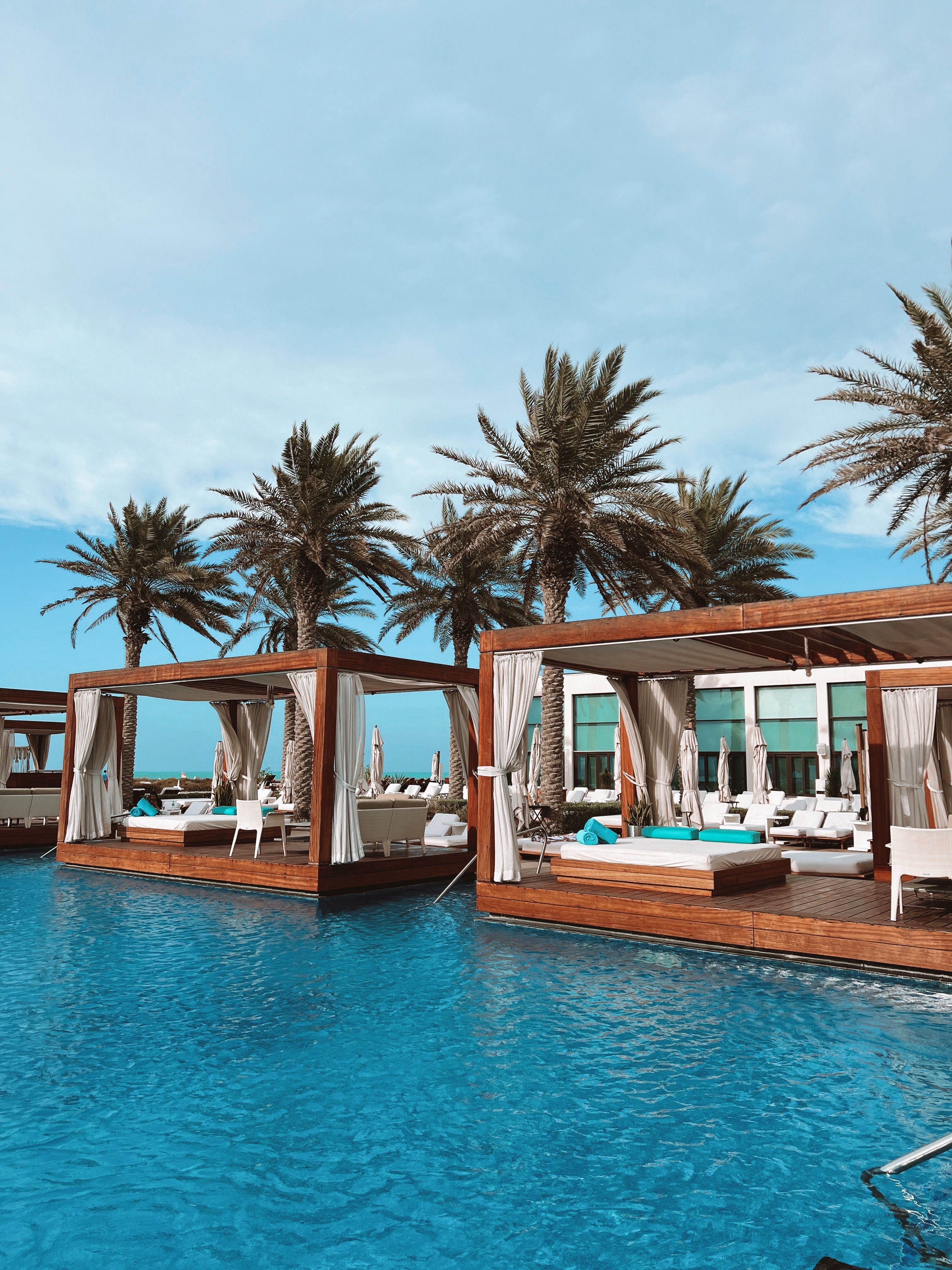 Poolside cabanas surrounded by palms